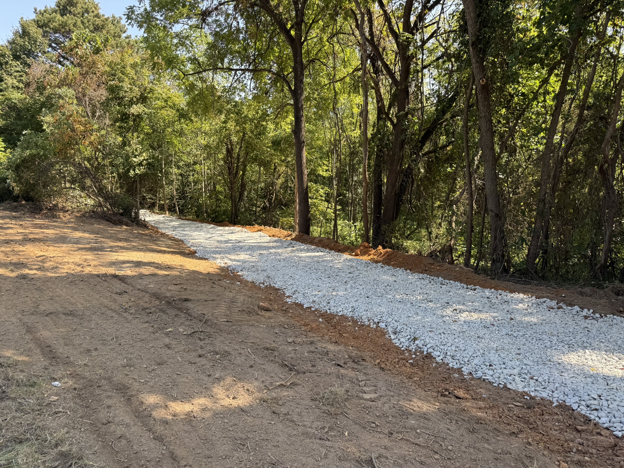New gravel driveway through wooded land